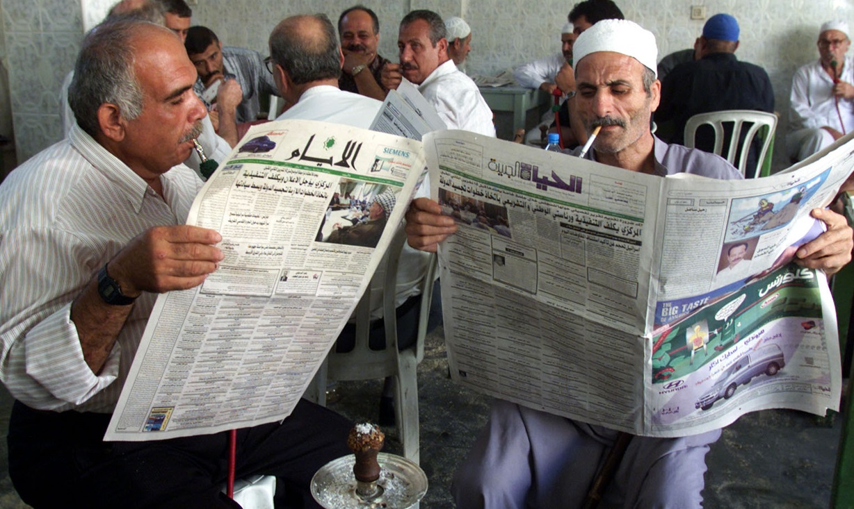 עזתים קוראים בעיתון על המסקנות מכינוס אש"ף, ספטמבר 2000. צילום: רויטרס