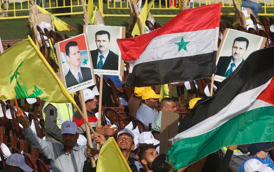 Supporters of Lebanon's Hezbollah leader Sayyed Hassan Nasrallah carry flags and pictures of Syria's President Bashar al-Assad. Photo: Reuters