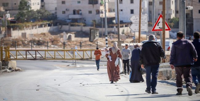 Palestinians in the West Bank cross a road closed by the Israeli army. Photo: Flash 90